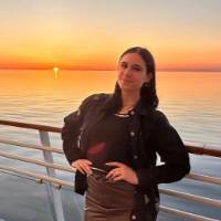 Woman posing on boat, hands on hips and smiling